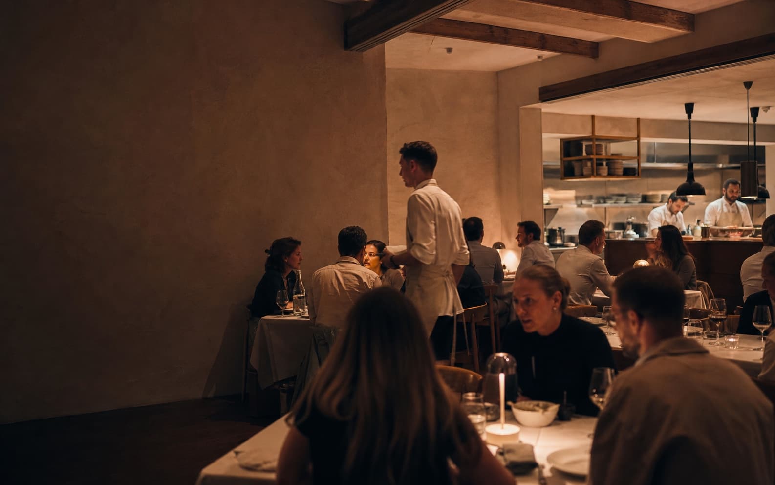Lebendiger Restaurantabend mit Gästen, Service und offener Küche