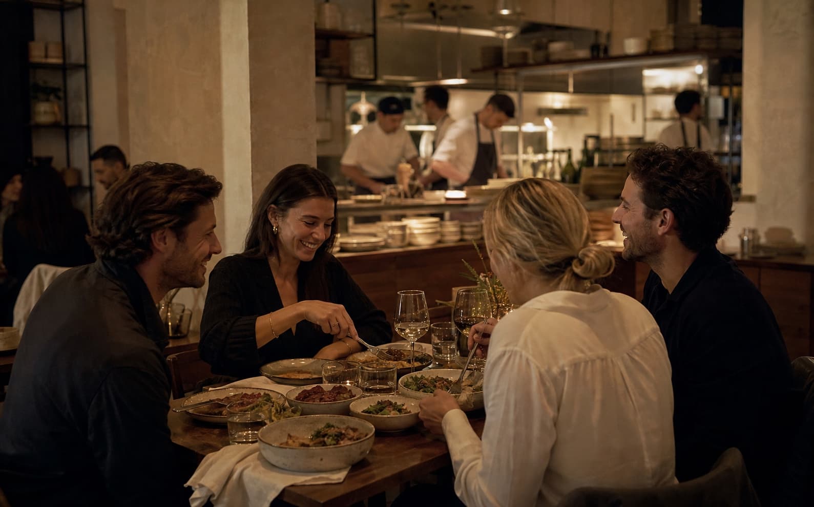 Vier Freunde teilen Gerichte und unterhalten sich im Restaurant