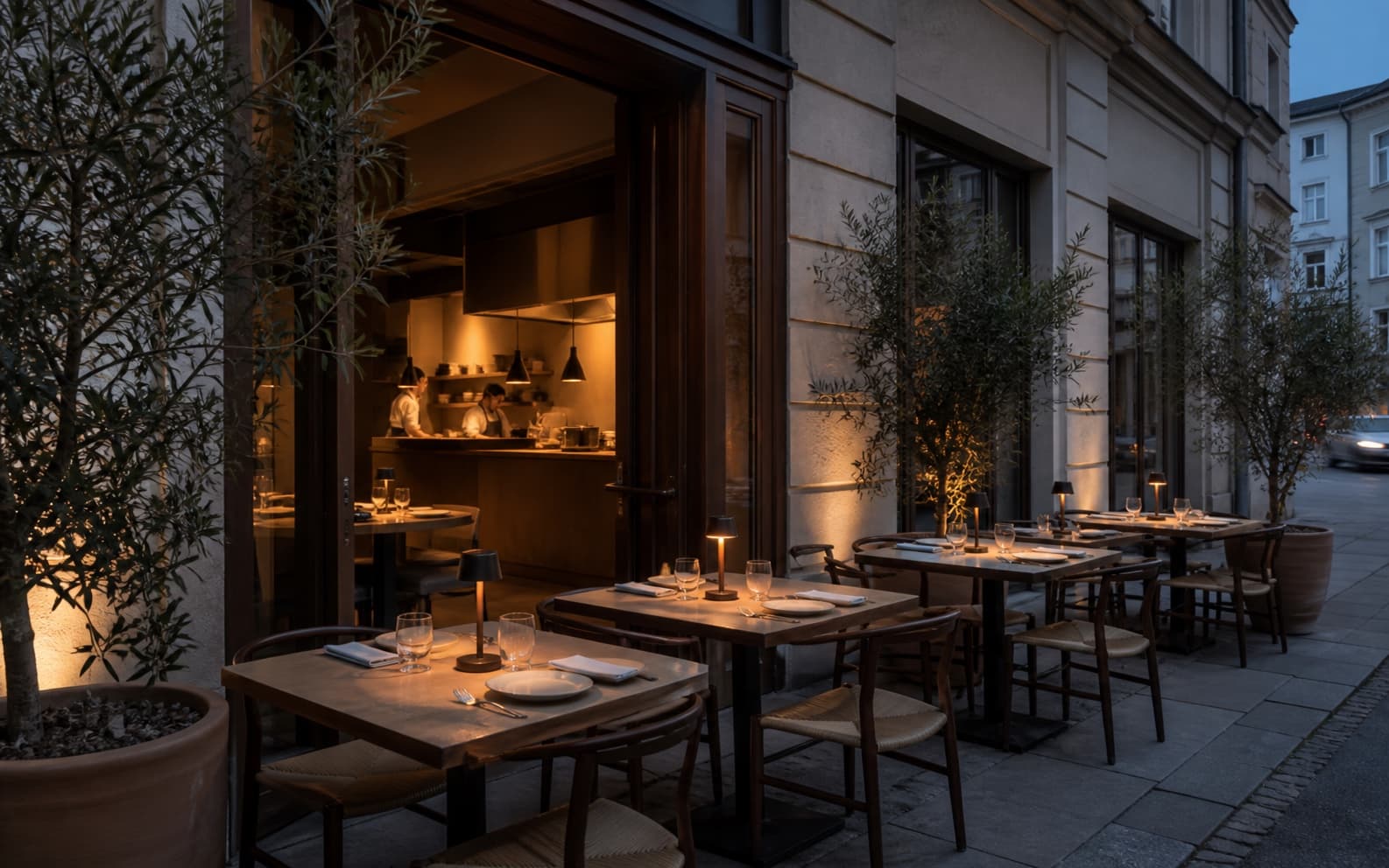 Ruhige Restaurantterrasse mit Olivenbäumen kurz vor der Öffnung