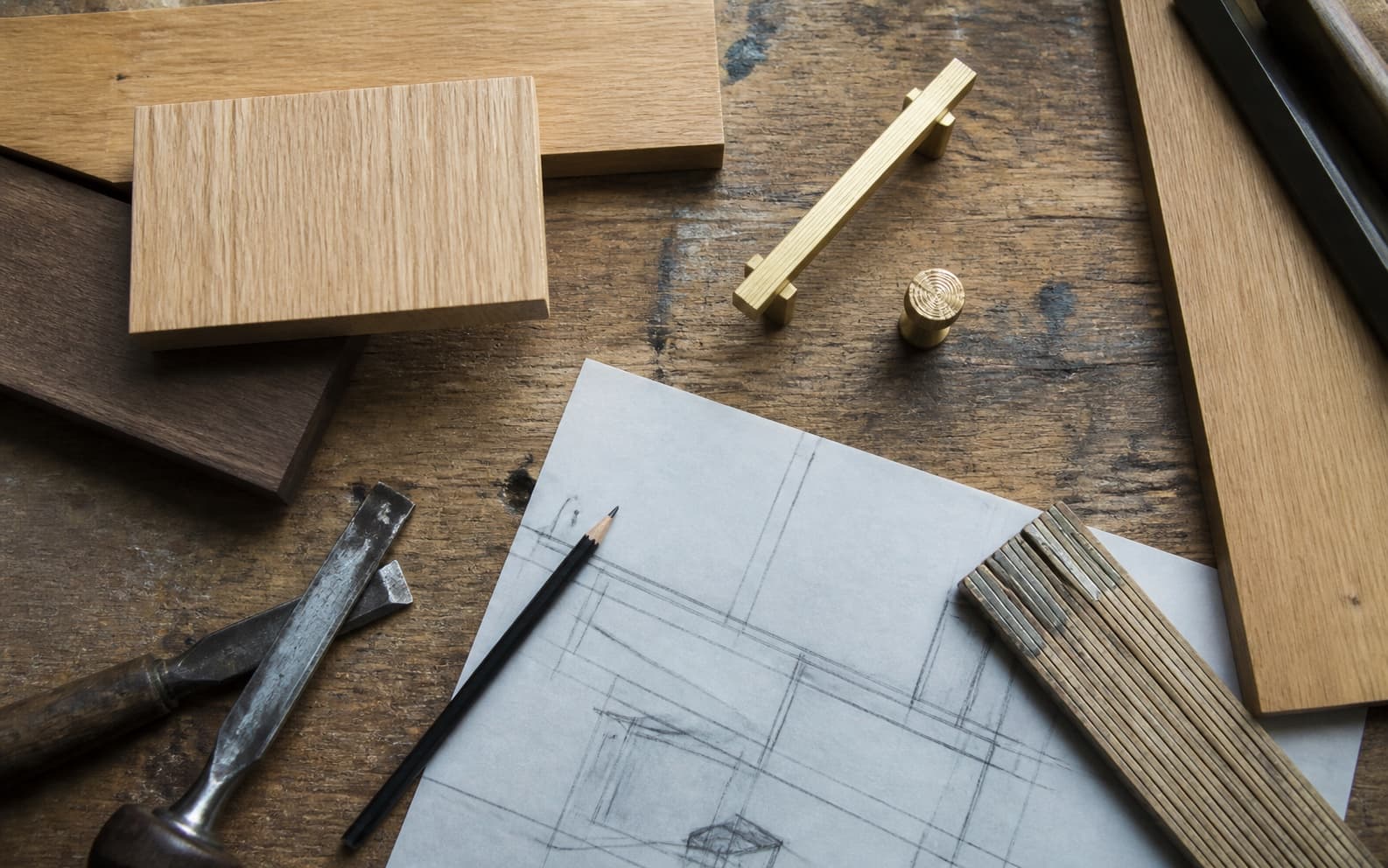 Materialmuster und Entwurfsskizze auf einem gebrauchten Werktisch